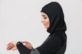 Young woman fitness muslim using watch clock isolated over white wall background