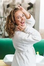 Image of young woman in housecoat standing in bathroom after shower