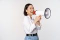 Image of young woman, korean activist, recruiter screaming in megaphone, searching, shouting at loudspeaker, standing