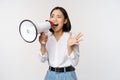 Image of young woman, korean activist, recruiter screaming in megaphone, searching, shouting at loudspeaker, standing