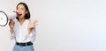 Image of young woman, korean activist, recruiter screaming in megaphone, searching, shouting at loudspeaker, standing