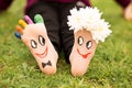 Images of lovely groom and bride just married painted in bright colors on feet of child outdoor at summer Royalty Free Stock Photo