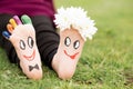 Images of lovely groom and bride just married painted in bright colors on feet of child outdoor at summer.