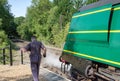 Detailed front view of a famous, British Steam Locomotive showing letting off steam while at a railway station.