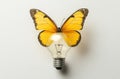 An imaginary light bulb with yellow butterflies inside, standing vertically on a table. The light bulb represents Royalty Free Stock Photo