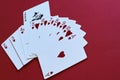 Imagination, allegory. Joker as original decision, driving force. Fan of playing cards of suit of hearts and black joker on red ba