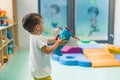 Imagination and creative thinking development. Toddler boy playing with a plane toy in a nursery school playroom.