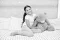 Imagination and development. Happy child cuddle teddy bear in bed. Little girl smile with childhood playmate. Enjoying