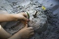 Imaginative creation made of sand by a child in a sandbox. Hands of a little girl playing with sand Royalty Free Stock Photo