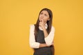 Imaginative girl child in school uniform keep thinking yellow background, imagination