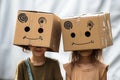 Imaginative play two little girls with cardboard boxes as headgear