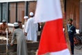 Imam speaking to Indonesian Muslim men against Indonesia national flag