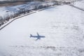 Black shadow from airplane on snowy field