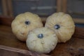 Three bumpy yellow gourds are placed in a wooden crate. Royalty Free Stock Photo