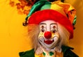 Colourful clown on a yellow background with a big round nose