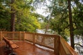 a sturdy wooden cedar observation deck extends gracefully over the banks of a tranquil river in Michigan.