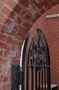 A Metal Gate Guards The Entry to a Brick Courtyard