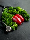 Imitation of healthy lungs and heart formed by broccoli and pepper with stethoscope