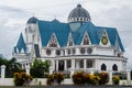 Immaculate Conception Cathedral surrounded by plants under a cloudy sky in Apia, Samoa