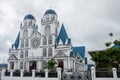 Immaculate Conception Cathedral surrounded by plants under a cloudy sky in Apia, Samoa Royalty Free Stock Photo