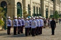 An immaculate row of uniformed soldiers, distinguished by their white helmets, stands in