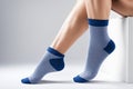 Close-up of woman\'s legs gracefully posed on the floor adorned in trendy blue patterned socks