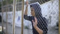 Immigrant teenager behind fence dreaming about bright future and safety, refugee Royalty Free Stock Photo