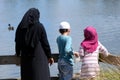 Immigrants muslim family feed ducks in a pond Royalty Free Stock Photo