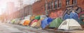 Immigrants temporary tent camp at dysfunctional district. Homeless refugees sleepover place in abandoned urban block