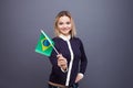 Immigration and the study of foreign languages, concept. A young smiling woman with a Brazil flag in her hand.