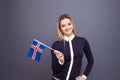 Immigration and the study of foreign languages, concept. A young smiling woman with a Iceland flag in her hand.