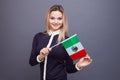 Immigration and the study of foreign languages, concept. A young smiling woman with a Mexico flag in her hand.