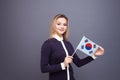 Immigration and the study of foreign languages, concept. A young smiling woman with a Republic of Korea flag