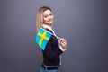 Immigration and the study of foreign languages, concept. A young smiling woman with a Sweden flag in her hand.