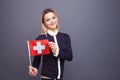 Immigration and the study of foreign languages, concept. A young smiling woman with a Switzerland flag in her hand.
