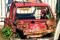 Red rusted and scraped car wreck.