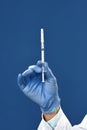 Immunisation. Cropped shot of male doctor hand in blue sterile gloves holding syringe with vaccine from flu, coronavirus