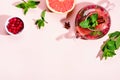 Immunity boosting drink. Mint Tea with cranberries, grapefruit and spices in glass teapot on pink table, trendy shadows Royalty Free Stock Photo