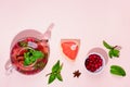 Immunity boosting drink. Mint Tea with cranberries, grapefruit and spices in glass teapot on pink table, trendy shadows Royalty Free Stock Photo