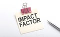 IMPACT FACTOR text on the sticker with pen on the white background Royalty Free Stock Photo