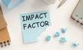 IMPACT FACTOR. text on white paper in a red notepad near different stationery Royalty Free Stock Photo