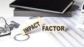 IMPACT FACTOR - text on a wooden block with chart and notebook Royalty Free Stock Photo