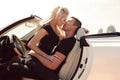 Impassioned couple in casual clothes, posing in luxurious car