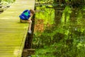 An Impatient Fishing Boy Stares At His Still Bobber As He Leans