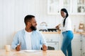 Impatient Hungry Black Husband Waiting For Food, Sitting At Table In Kitchen