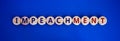 Impeachment symbol. Wooden circles with the word `impeachment`. Beautiful blue background, copy space. Business, impeachment