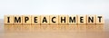 Impeachment symbol. Wooden cubes with the word `impeachment`. Beautiful wooden table, white background, copy space. Business,