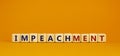 Impeachment symbol. Wooden cubes with the word `impeachment`. Beautiful orange background, copy space. Business, impeachment