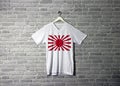 The Imperial Japanese Army war flag on shirt and hanging on the wall with brick pattern wallpaper Royalty Free Stock Photo