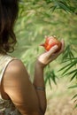 Impersonal brunette in the summer dress holding the red apple